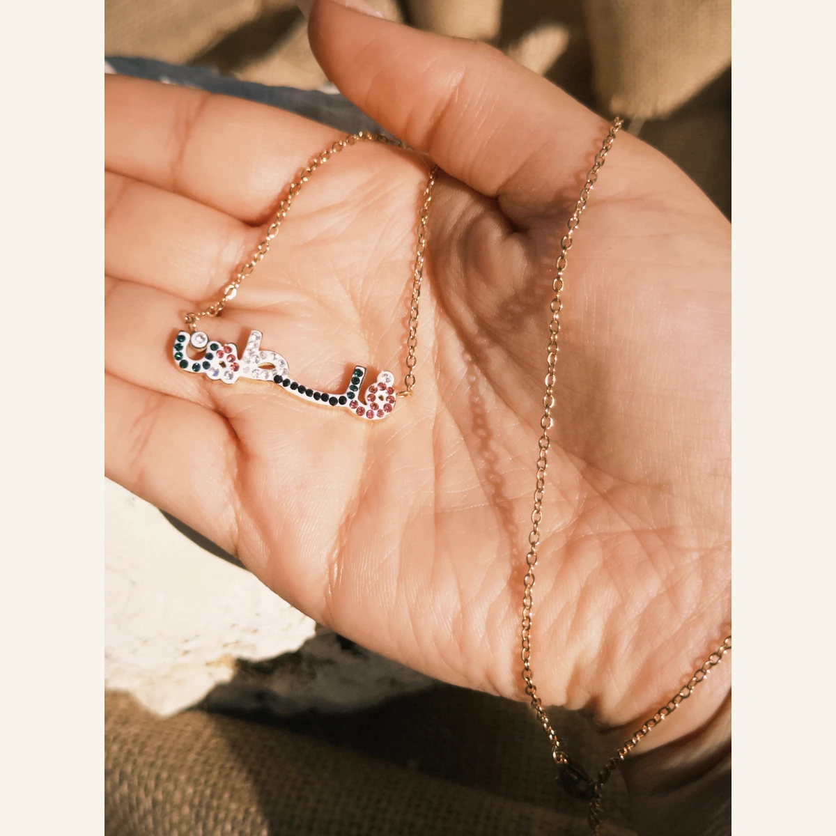 Multicolor Filastin Necklace held in hand to show its size