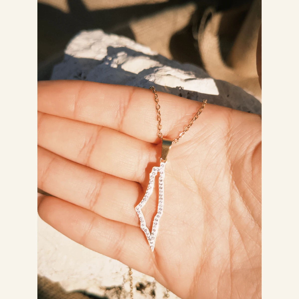 Sparkling Palestine Outline Necklace held in hand to show its size