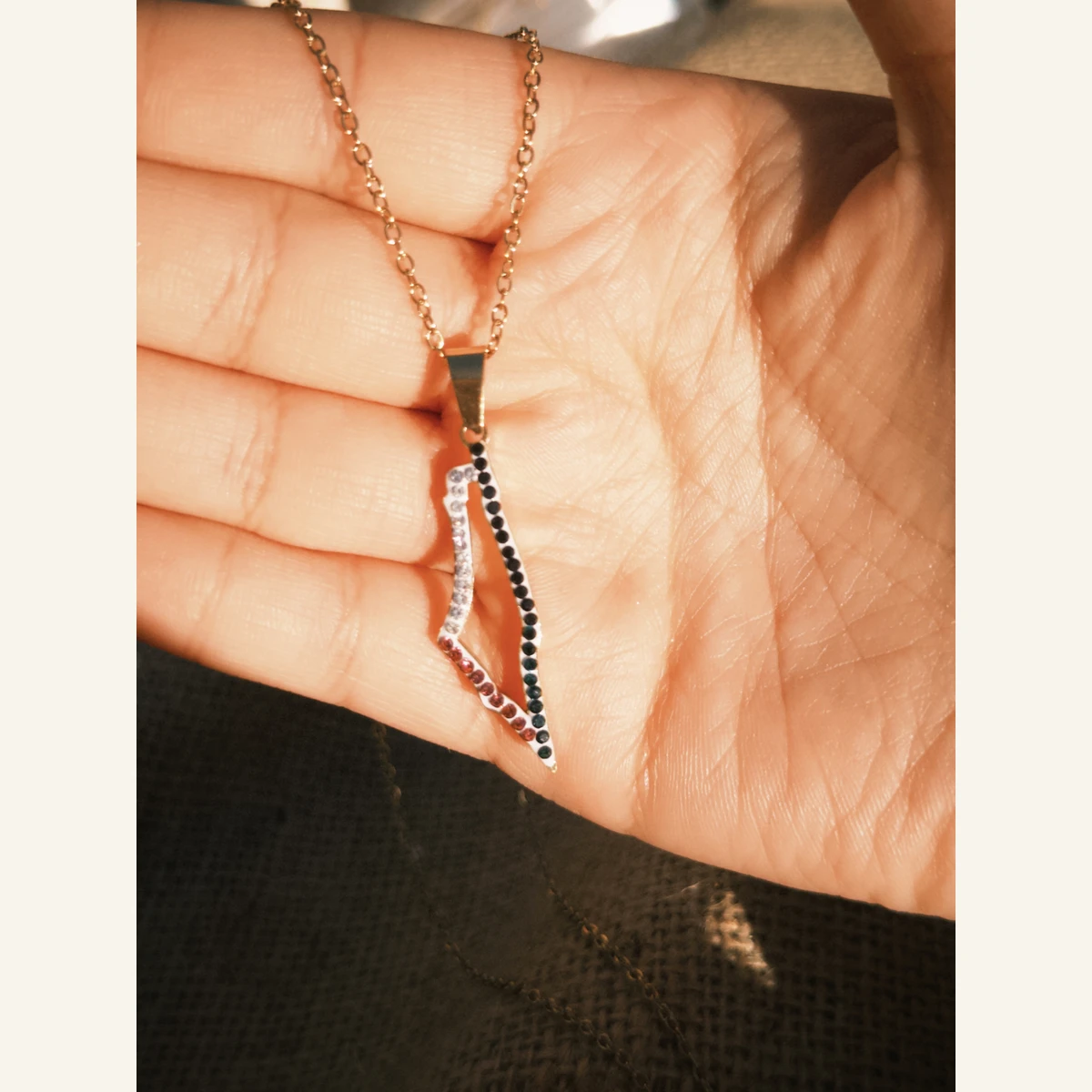 Palestinian Flag Map Necklace held in hand to show its size