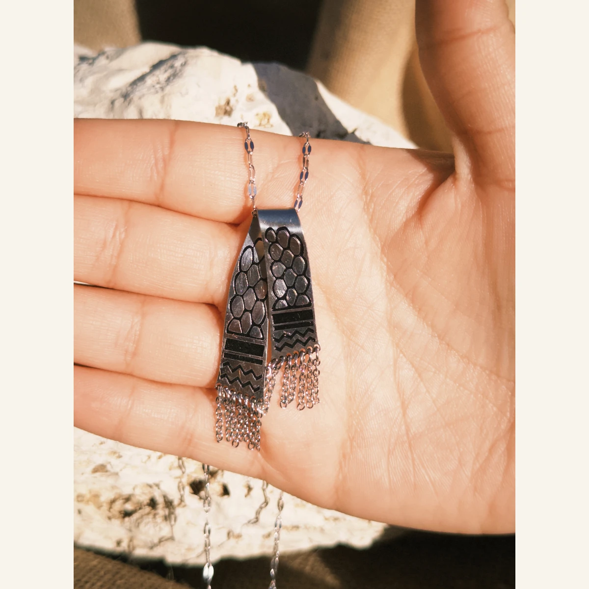 Silver-Tone Keffiyeh Necklace held in hand to show its size