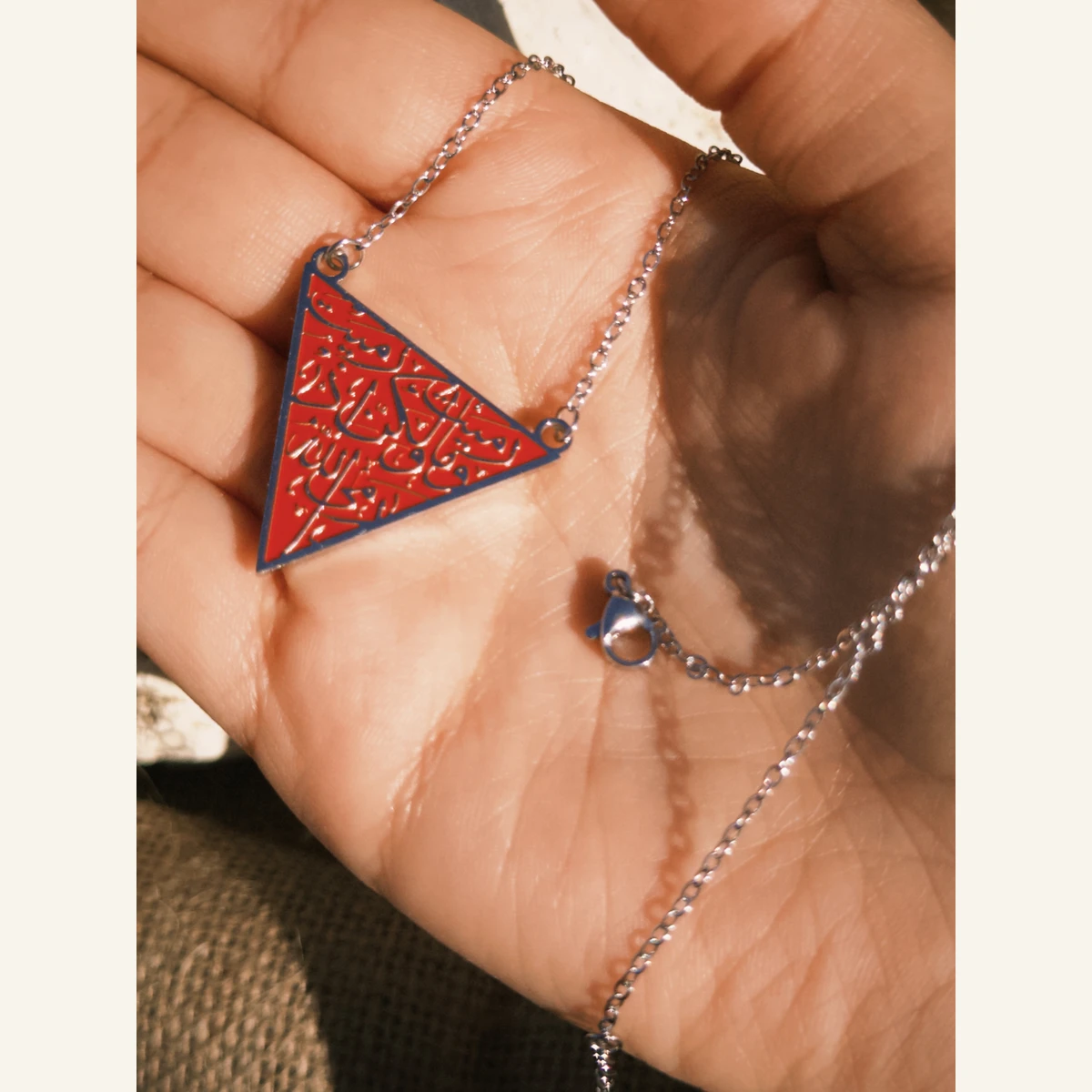 Red Triangle Pattern Necklace held in hand to show its size