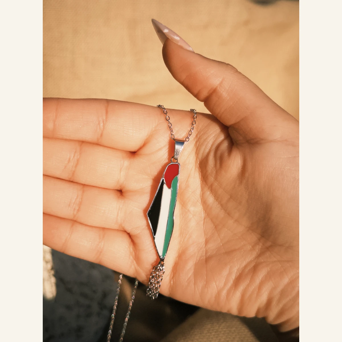 Palestinian Flag Pendant Necklace held in hand to show its size